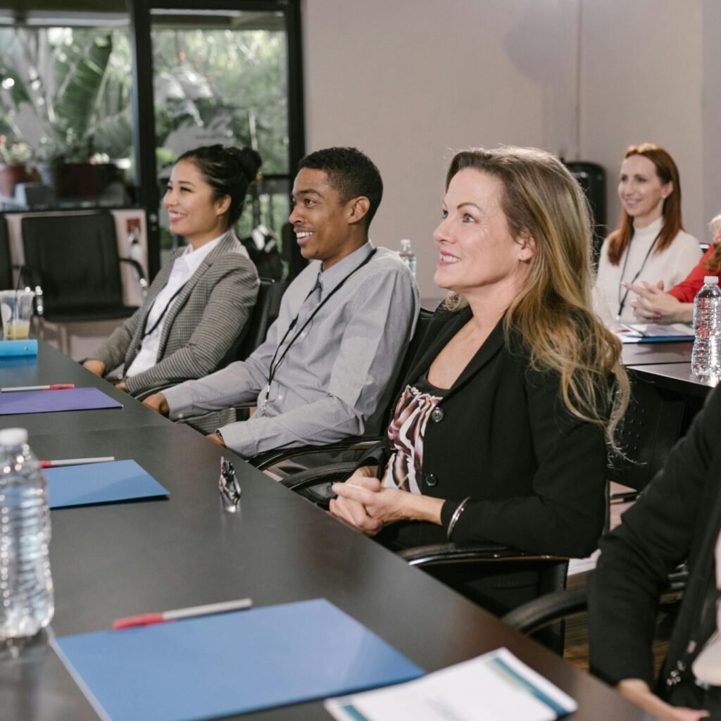 A diverse group attending a seminar in a professional setting, focused and engaged.